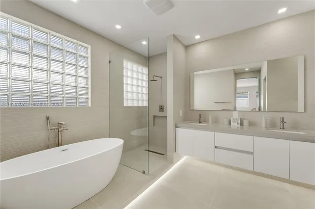 a bathroom with a double vanity sink mirror and shower