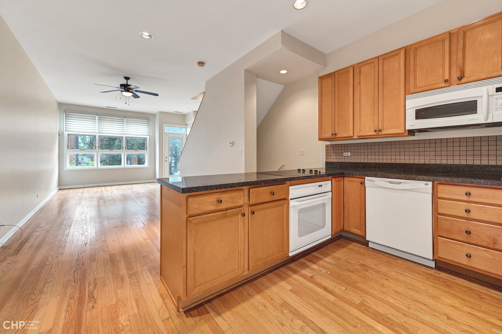 855 West Erie Street, Unit 126 Chicago, IL 60642 - Photo 3 of 24 a kitchen with granite countertop a stove a sink and white cabinets with wooden floor