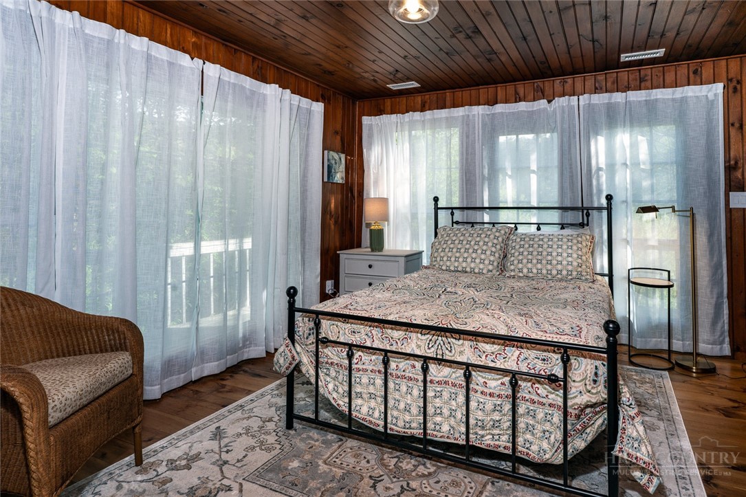 217 Holiday Hills Drive Boone, NC 28607 - Photo 17 of 26 a bedroom with a bed a mirror with the wooden floor