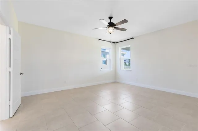 a view of an empty room and chandelier fan