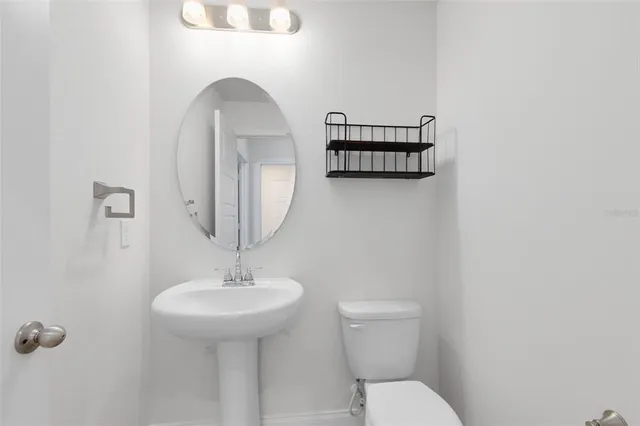 a bathroom with a toilet a sink and mirror