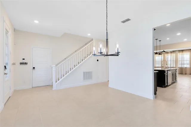 a view of a kitchen with stairs and a view of living room