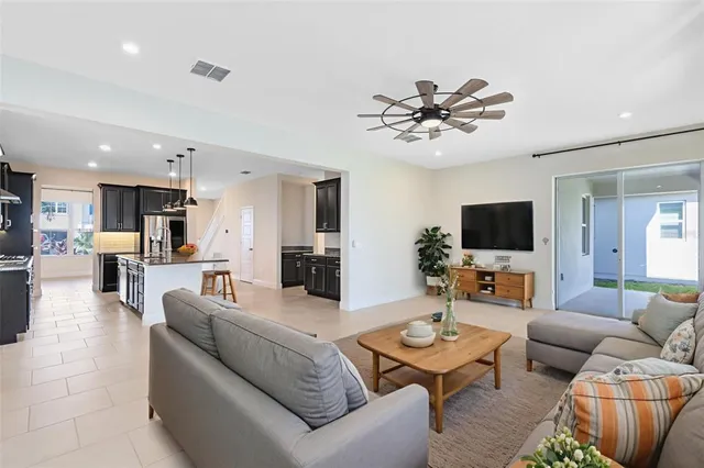 a living room with furniture kitchen view and a flat screen tv