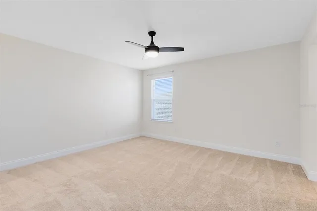 an empty room with a window and a ceiling fan