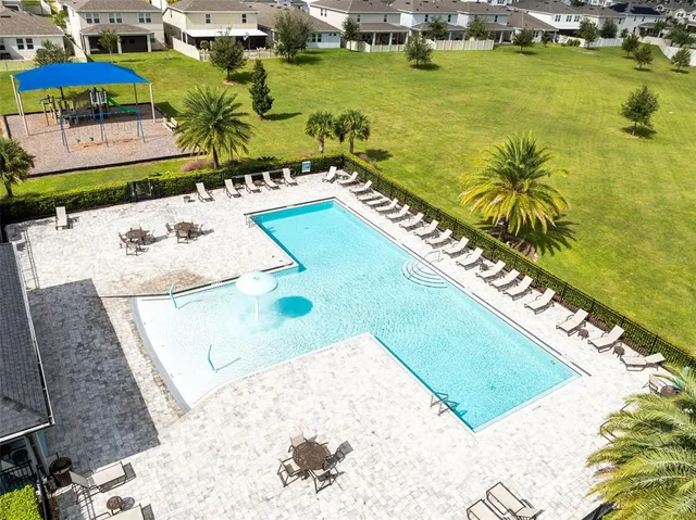 an aerial view of residential houses with outdoor space and swimming pool