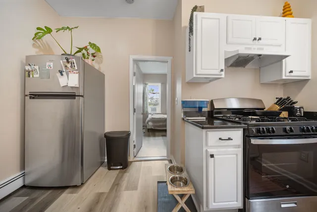 a kitchen with white cabinets and refrigerator