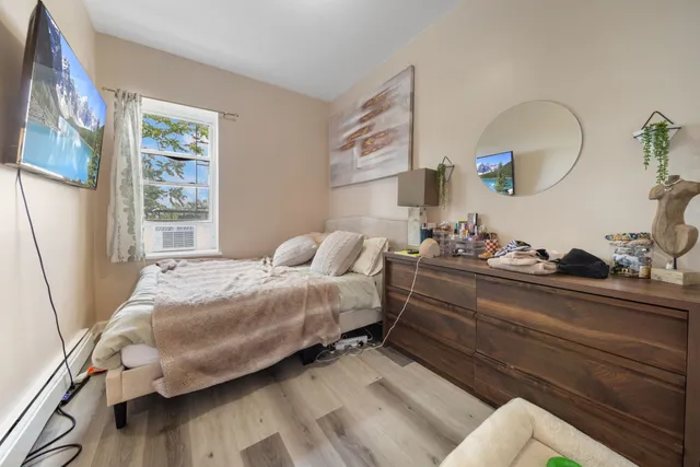 a bedroom with bed and wooden floor