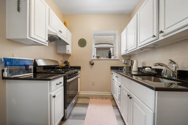 a kitchen with stainless steel appliances granite countertop a sink stove and cabinets