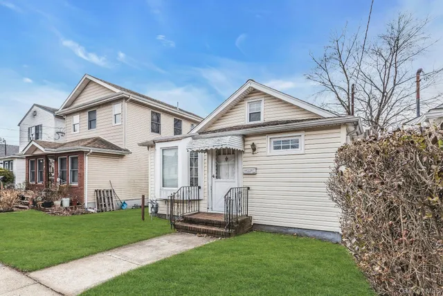 a front view of a house with a garden and plants