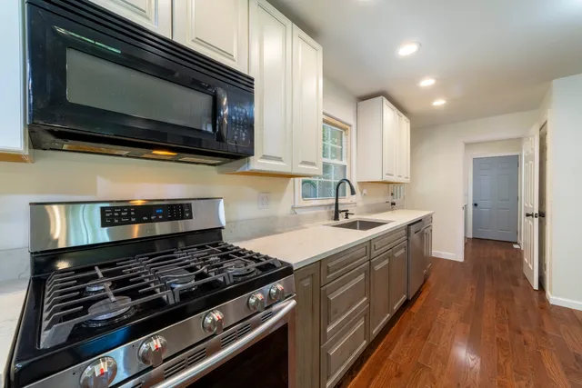 a view of a kitchen with wooden floor and a refrigerator