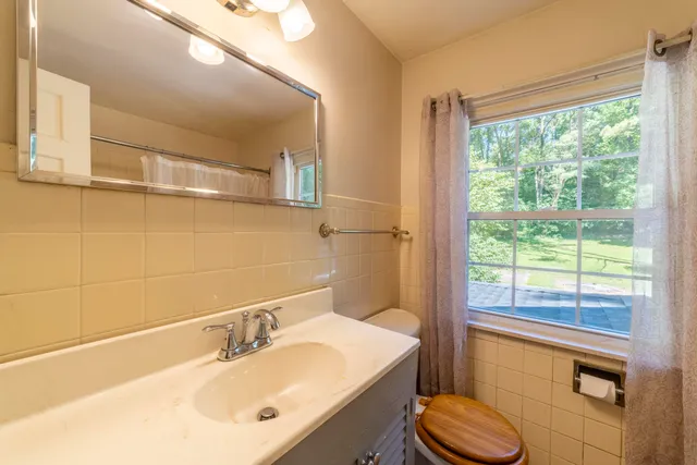 an empty room with windows closet and chandelier fan