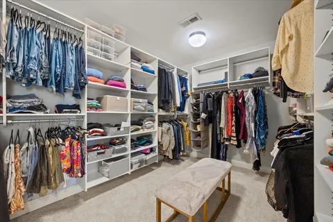 a view of walk in closet with clothes