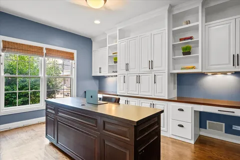 a view of cabinets a wooden floor and a window in the kitchen