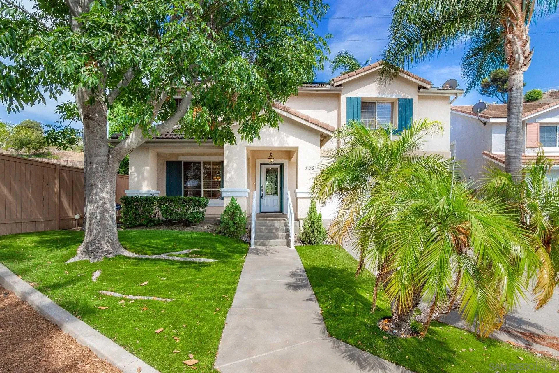 a front view of a house with a yard and potted plants