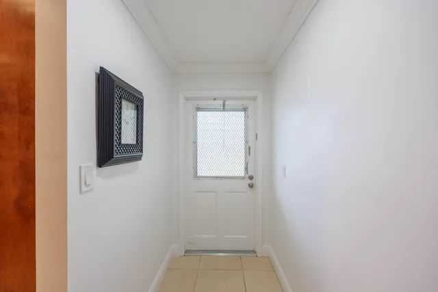 a view of an empty room with wooden floor and windows