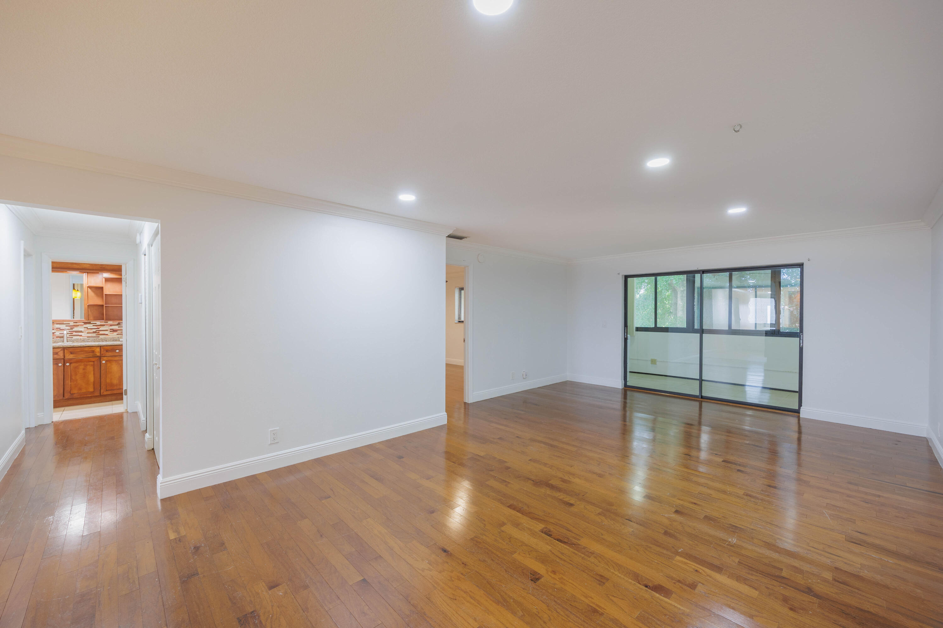 3001 Linton Boulevard, Unit 213C Delray Beach, FL 33445 - Photo 13 of 35 a view of an empty room with wooden floor and windows