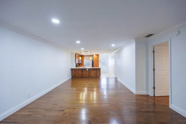 a view of a big room with wooden floor and windows