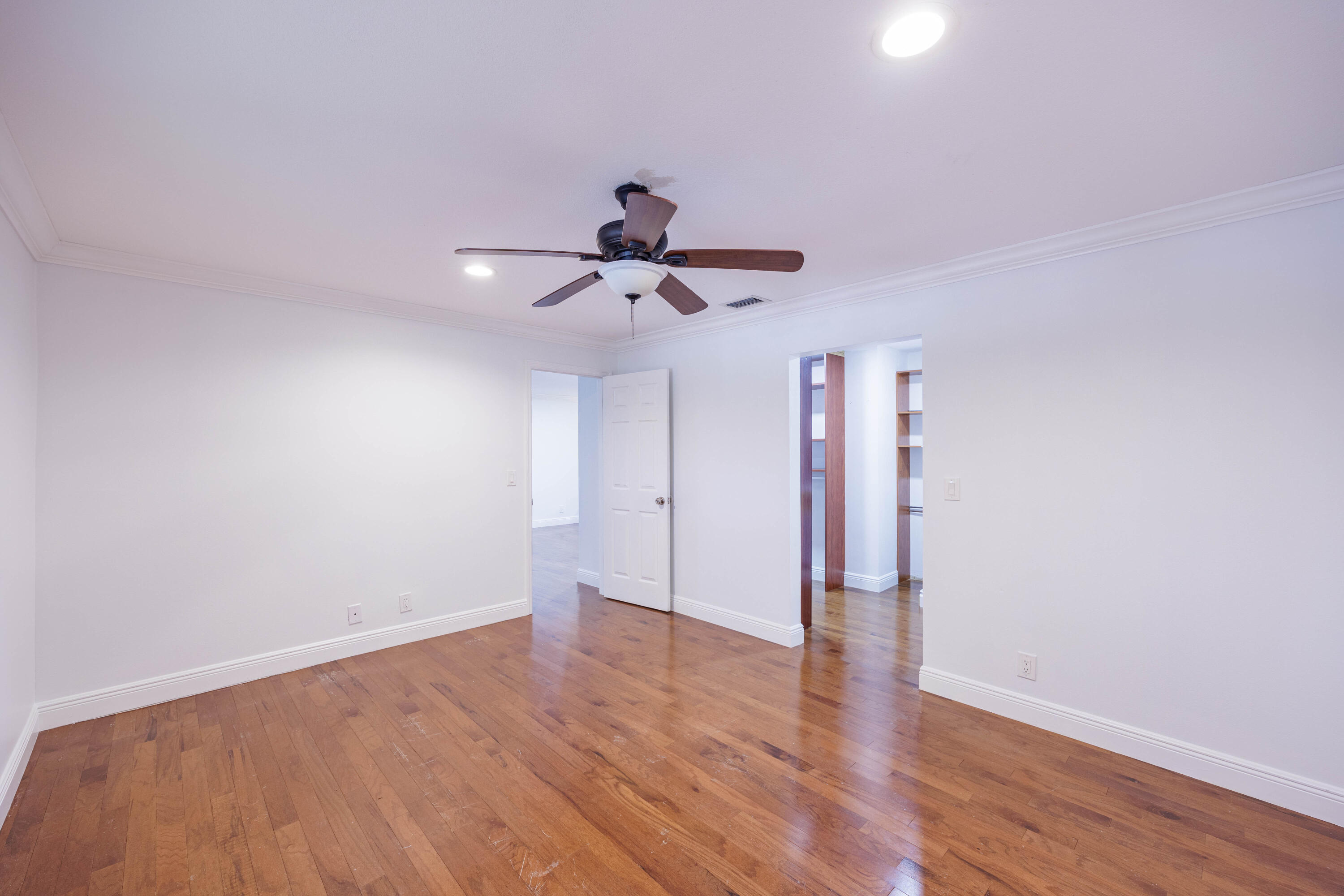 3001 Linton Boulevard, Unit 213C Delray Beach, FL 33445 - Photo 15 of 35 a view of empty room with wooden floor and ceiling fan