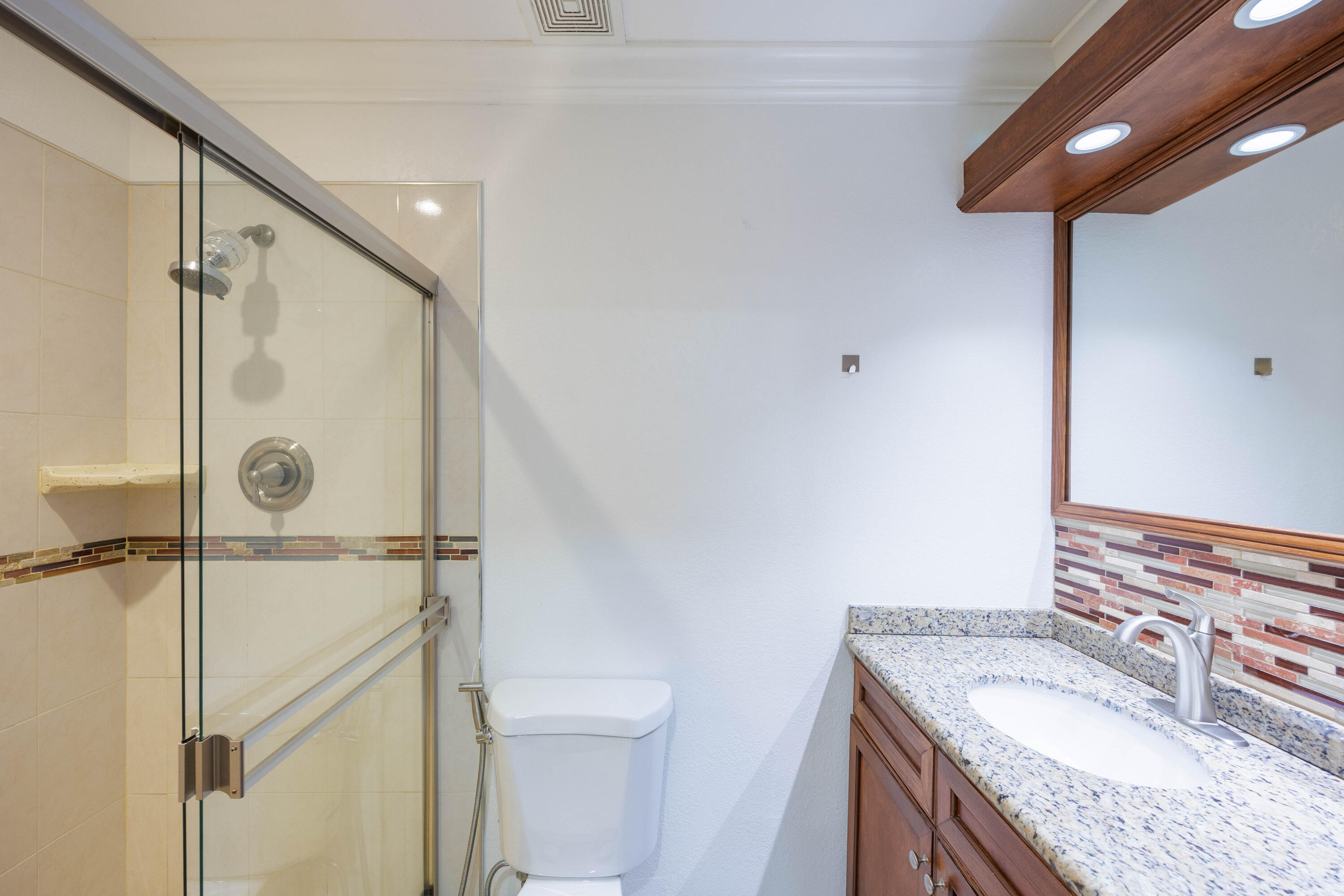 3001 Linton Boulevard, Unit 213C Delray Beach, FL 33445 - Photo 20 of 35 a bathroom with a granite countertop sink mirror vanity and toilet
