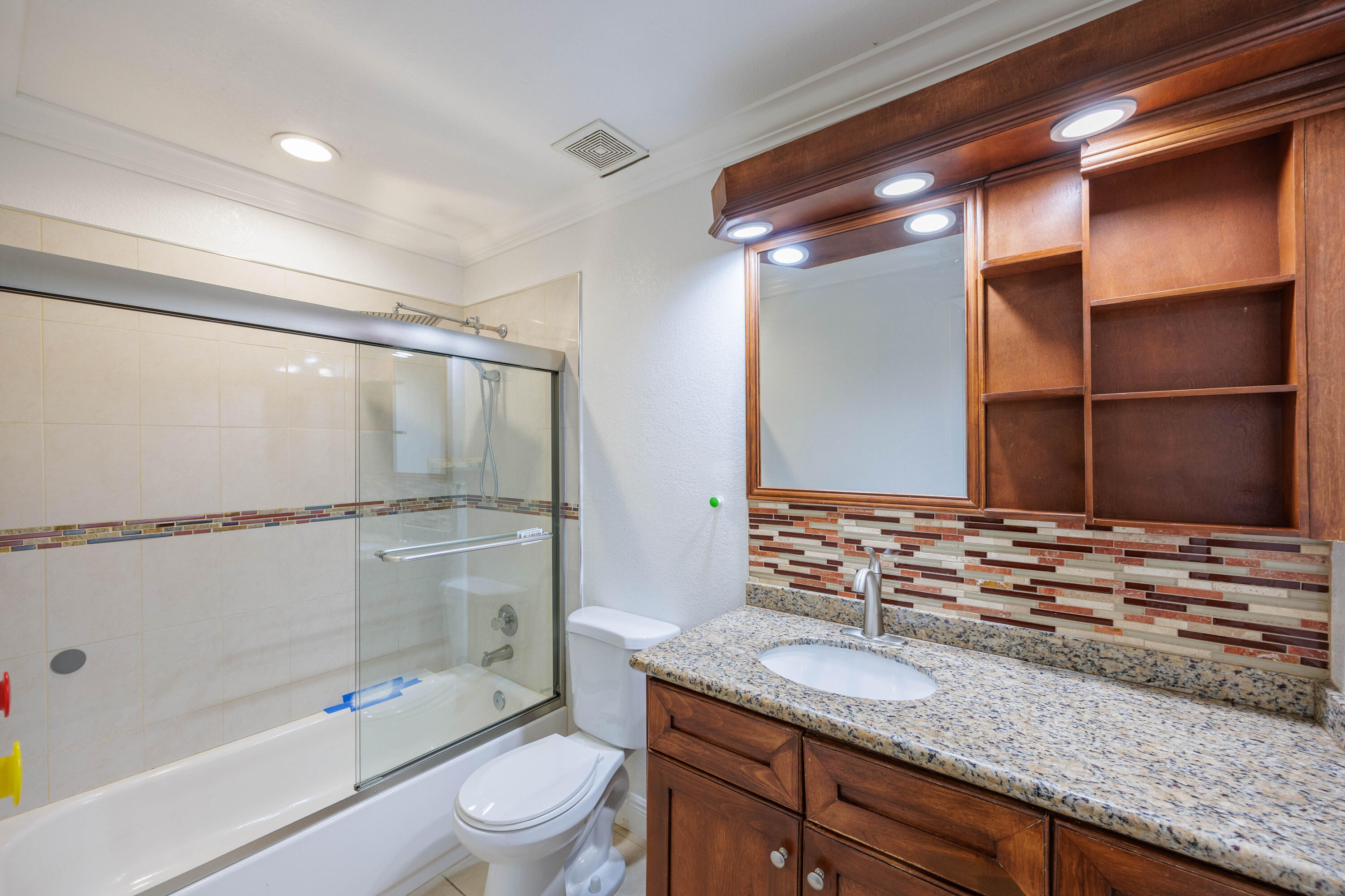 3001 Linton Boulevard, Unit 213C Delray Beach, FL 33445 - Photo 28 of 35 a bathroom with a granite countertop sink a toilet and shower