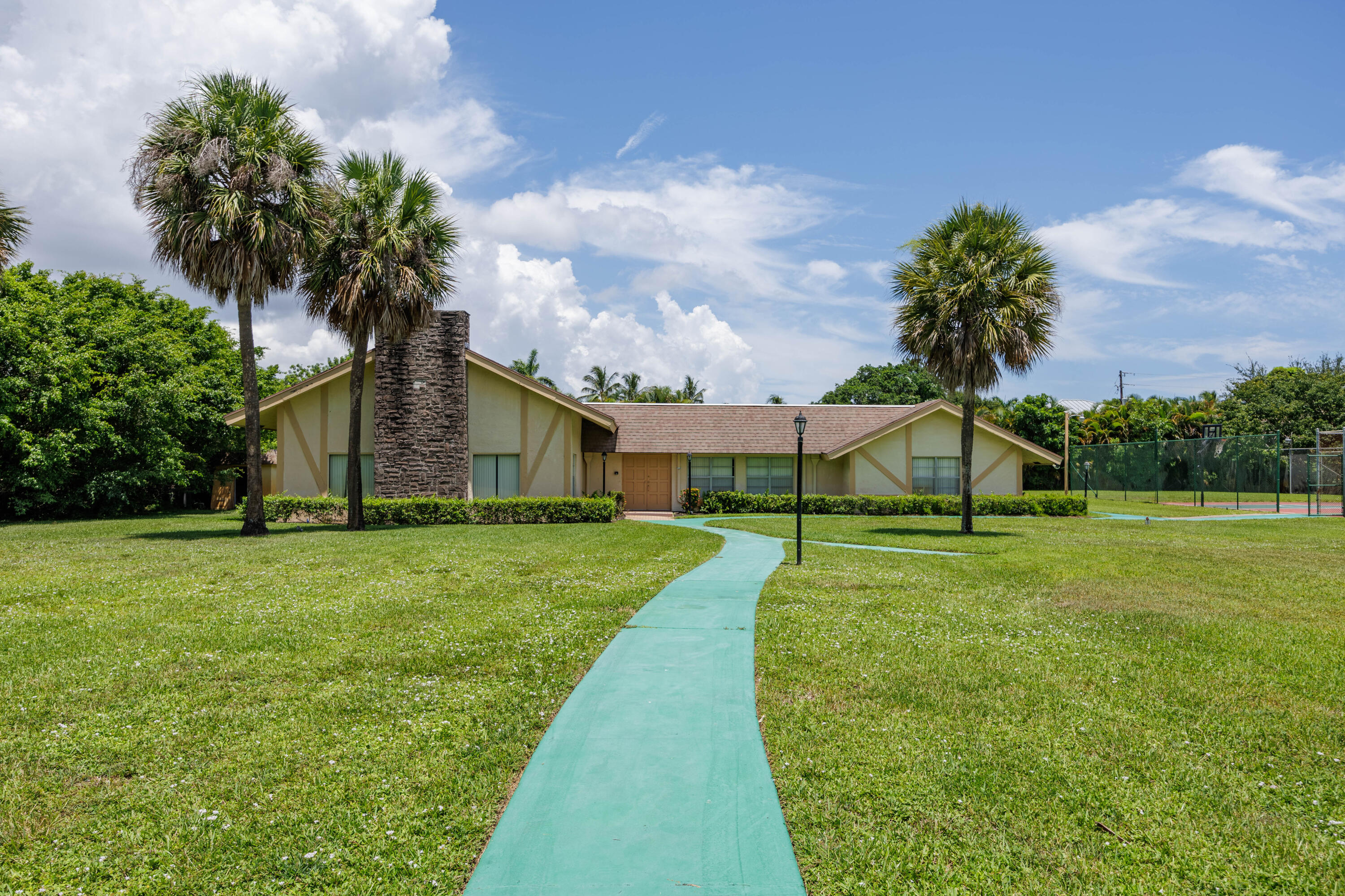 3001 Linton Boulevard, Unit 213C Delray Beach, FL 33445 - Photo 3 of 35 a view of a house with a big yard and palm trees