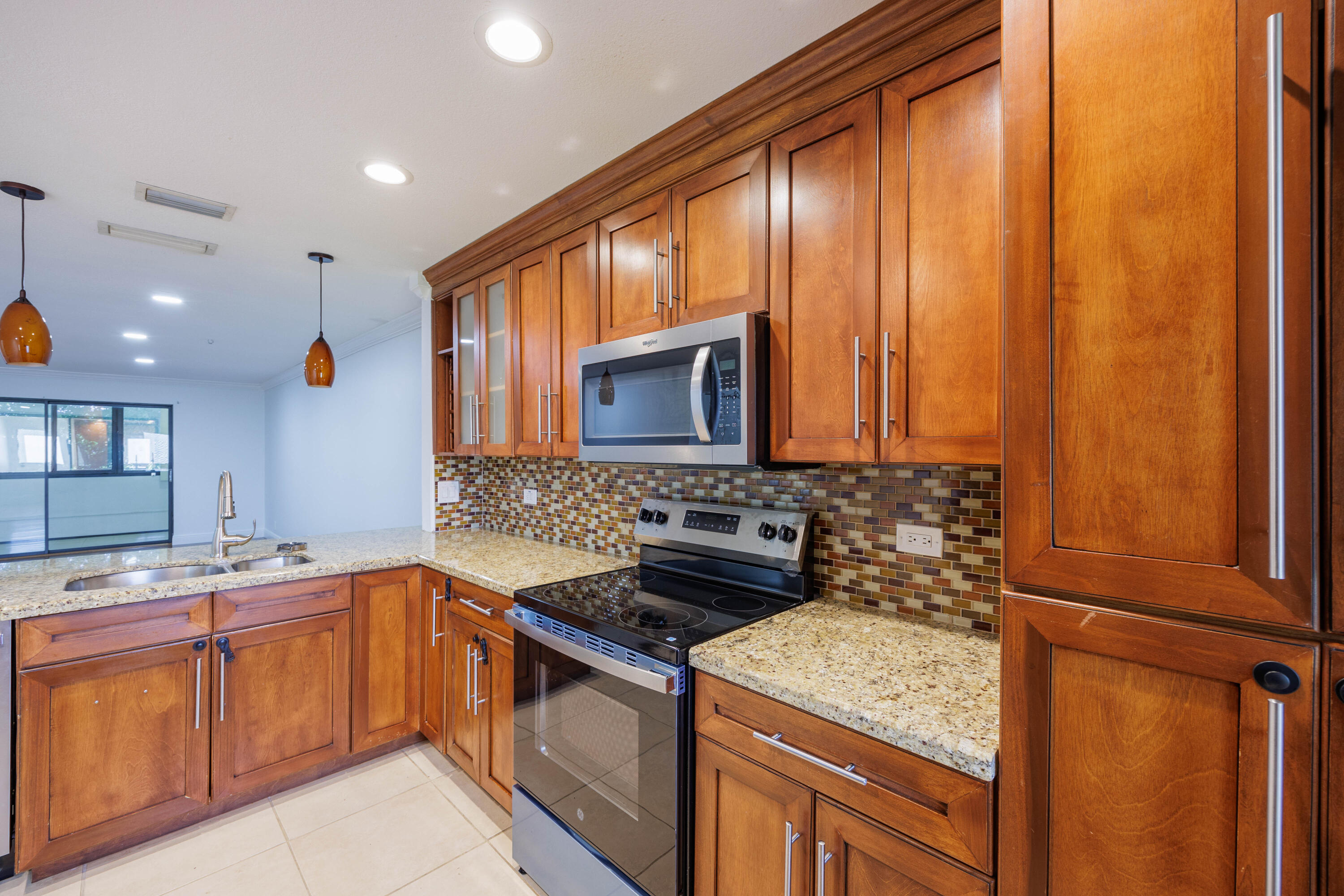 3001 Linton Boulevard, Unit 213C Delray Beach, FL 33445 - Photo 8 of 35 a kitchen that has a sink and a stove in it