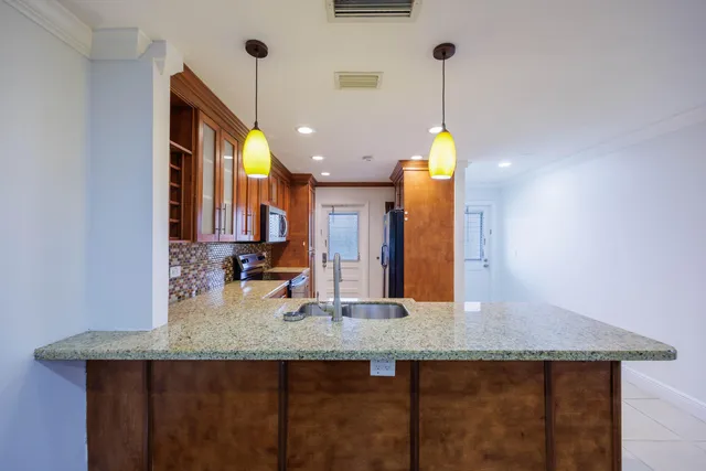 a kitchen with stainless steel appliances granite countertop a sink stove and refrigerator