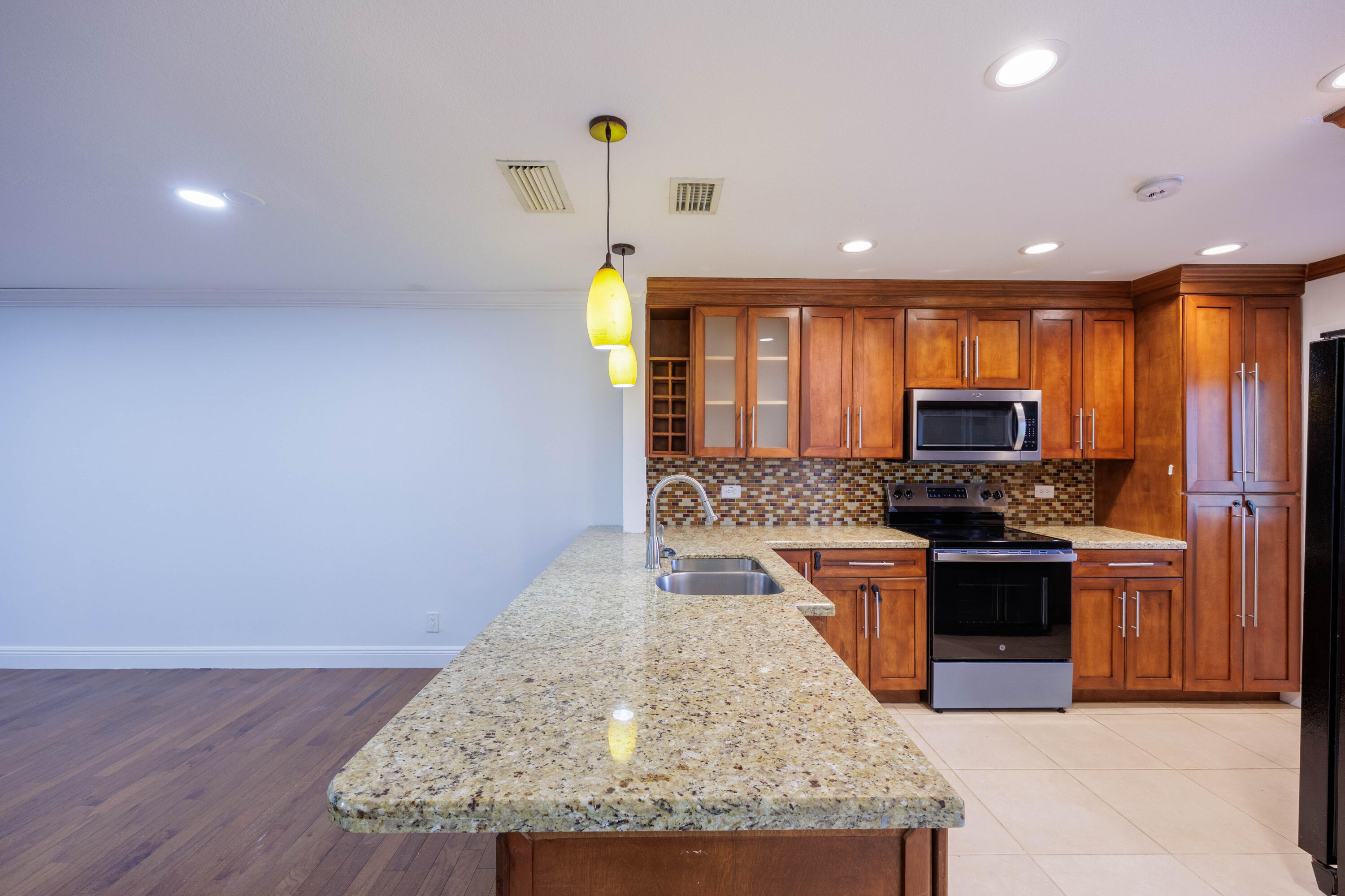 3001 Linton Boulevard, Unit 213C Delray Beach, FL 33445 - Photo 10 of 35 a kitchen with stainless steel appliances granite countertop a sink stove and refrigerator