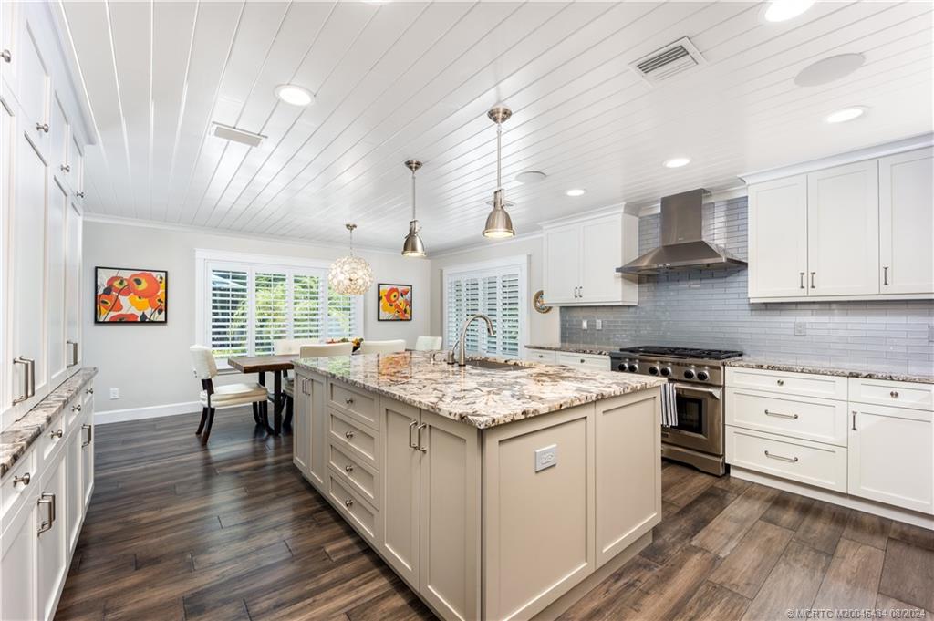 121 Hillcrest Drive Stuart, FL 34996 - Photo 21 of 65 a kitchen that has a lot of cabinets a sink stainless steel appliances and wooden floor