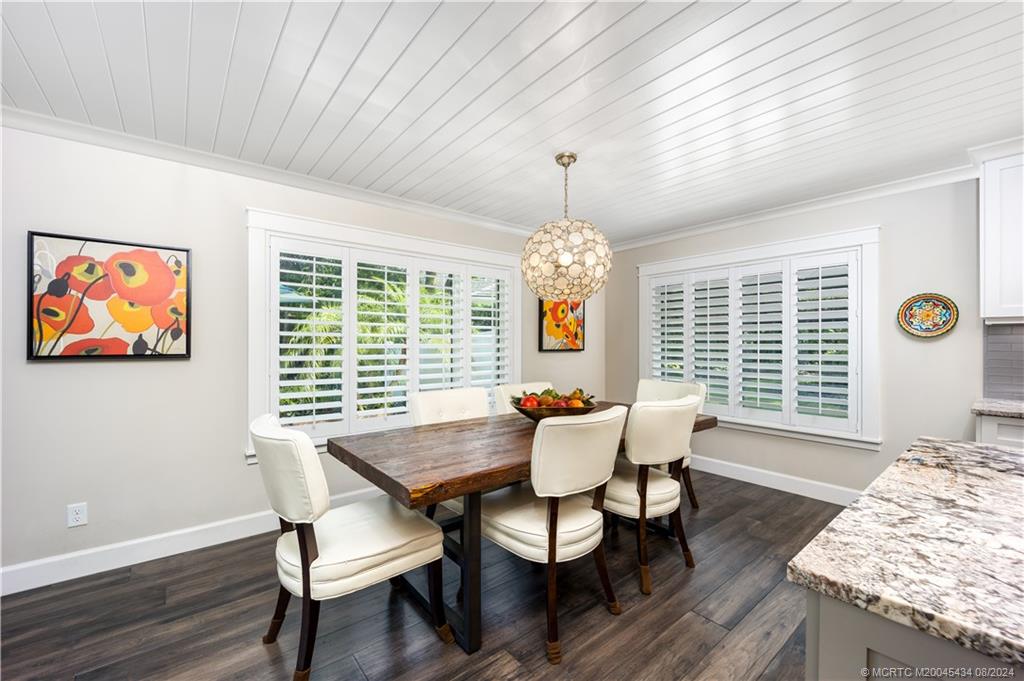 121 Hillcrest Drive Stuart, FL 34996 - Photo 24 of 65 a dining room with furniture a chandelier and wooden floor