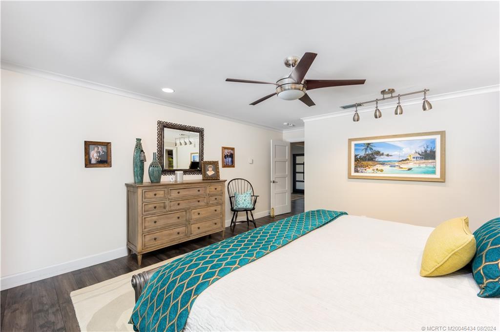 121 Hillcrest Drive Stuart, FL 34996 - Photo 28 of 65 a bedroom with a bed a dresser and painting on the wall
