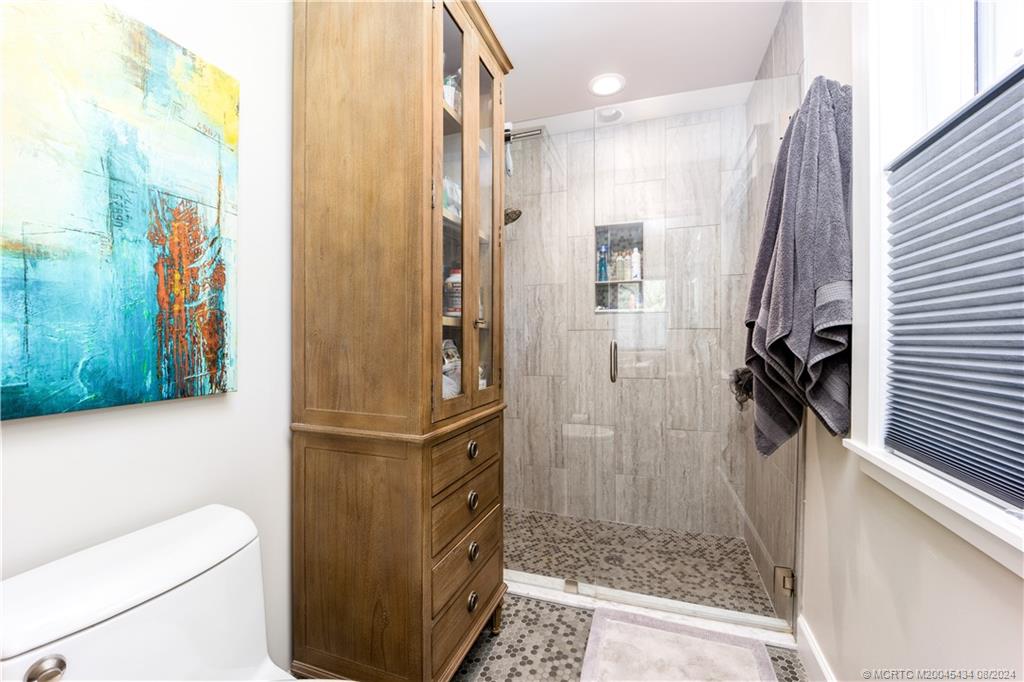 121 Hillcrest Drive Stuart, FL 34996 - Photo 33 of 65 a bathroom with a granite countertop shower a toilet and a sink