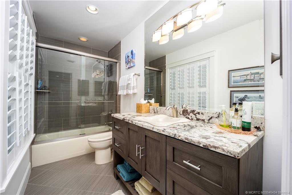 121 Hillcrest Drive Stuart, FL 34996 - Photo 36 of 65 a bathroom with a granite countertop sink a toilet and bathtub