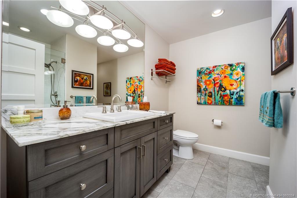 121 Hillcrest Drive Stuart, FL 34996 - Photo 39 of 65 a bathroom with a sink a toilet and a mirror