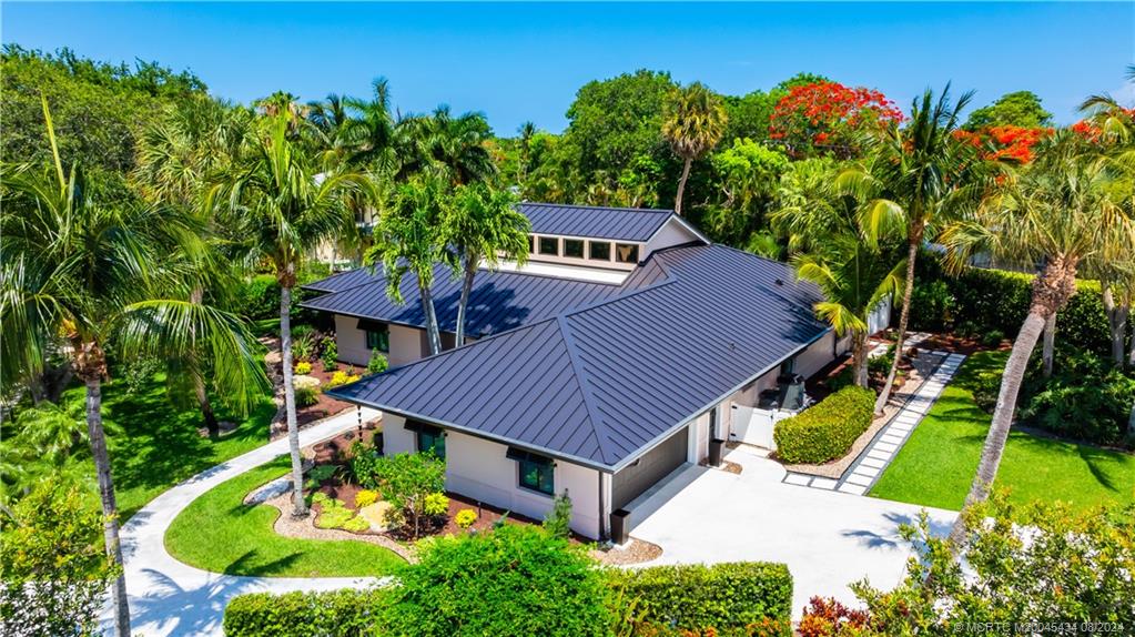 121 Hillcrest Drive Stuart, FL 34996 - Photo 4 of 65 a aerial view of a house with table and chairs under an umbrella