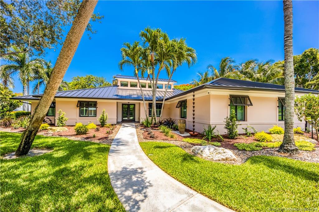 121 Hillcrest Drive Stuart, FL 34996 - Photo 65 of 65 a front view of a house with swimming pool patio and outdoor seating