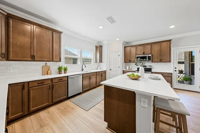 a kitchen with a stove a sink a microwave a refrigerator and cabinets
