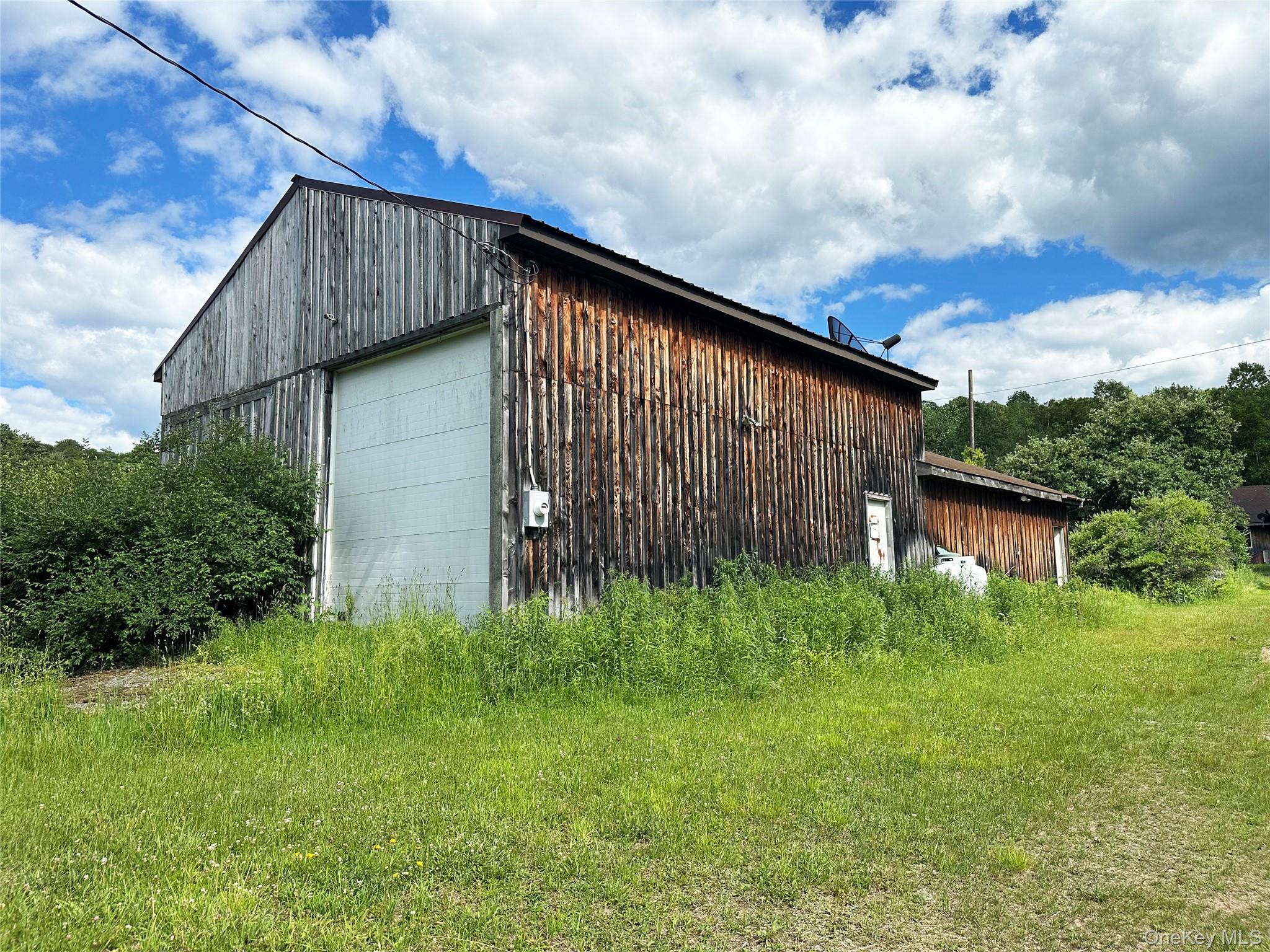 818 Methol Road Roscoe, NY 12776 - Photo 37 of 39 Large barn-style outbuilding with oversized garage door, high ceilings, and flexible space for garage, storage, equipment, workshop, or hobby use.