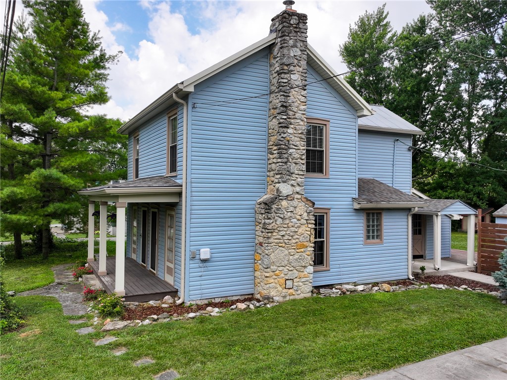 8707 Lytle Ferry Road Waynesville, OH 45068 - Photo 39 of 54 A charming home with a distinctive stone chimney, offering inviting outdoor spaces and established landscaping.