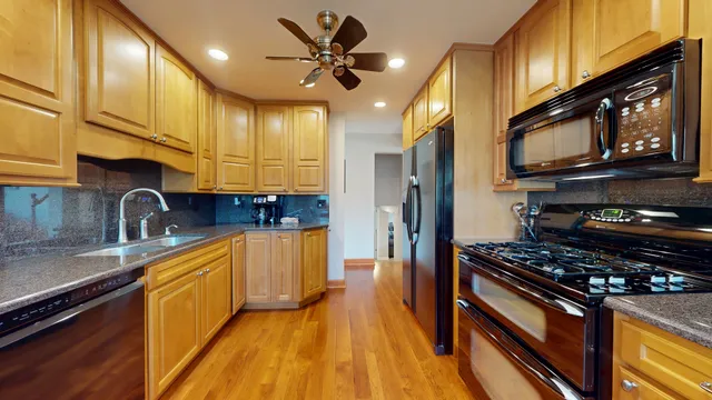 a kitchen with stainless steel appliances granite countertop a stove a sink and a refrigerator