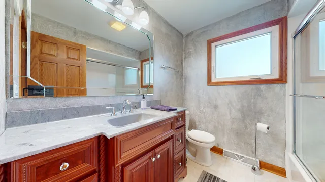 a bathroom with a sink a toilet and a mirror