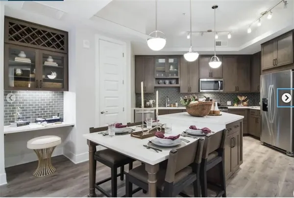 a kitchen with a table chairs stove and refrigerator