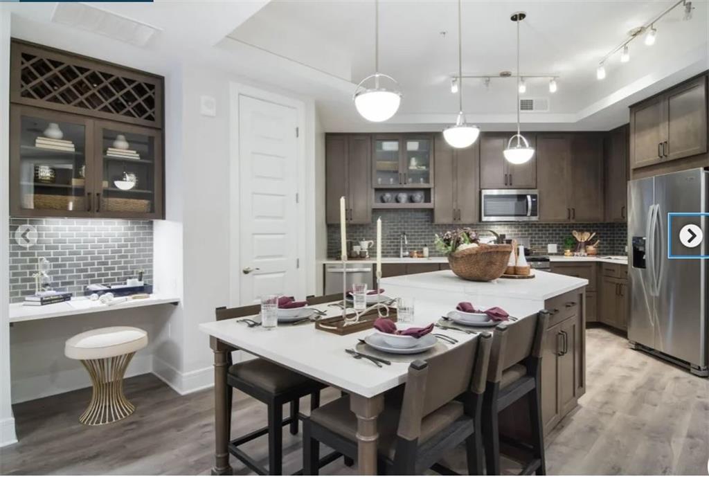 6500 Aria Boulevard, Unit 155 Sandy Springs, GA 30328 - Photo 2 of 7 a kitchen with a table chairs stove and refrigerator