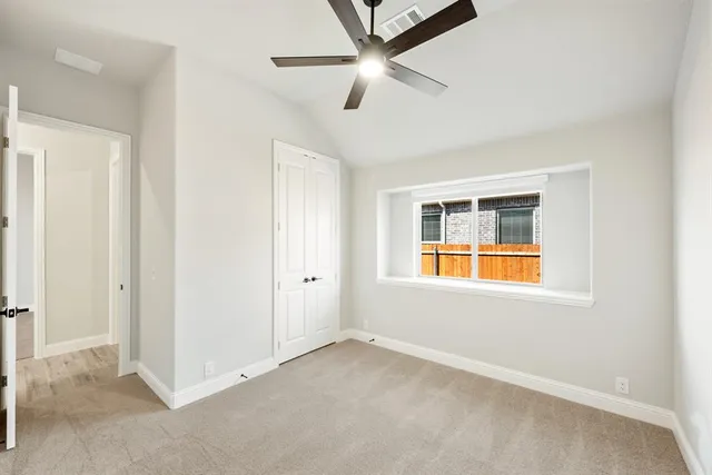 an empty room with a window and a fan