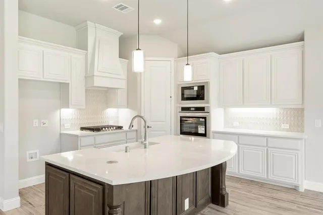 a kitchen with kitchen island a sink stainless steel appliances and cabinets