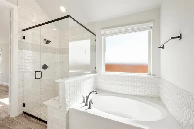 a bathroom with a white bath tub sitting next to a window