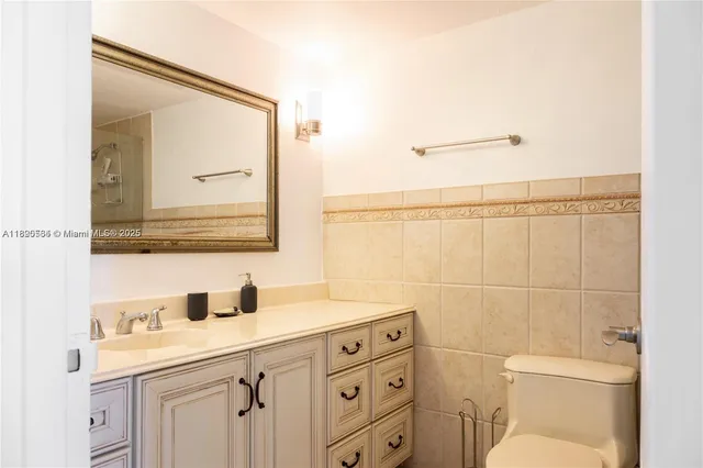 a bathroom with a toilet a sink a vanity and mirror