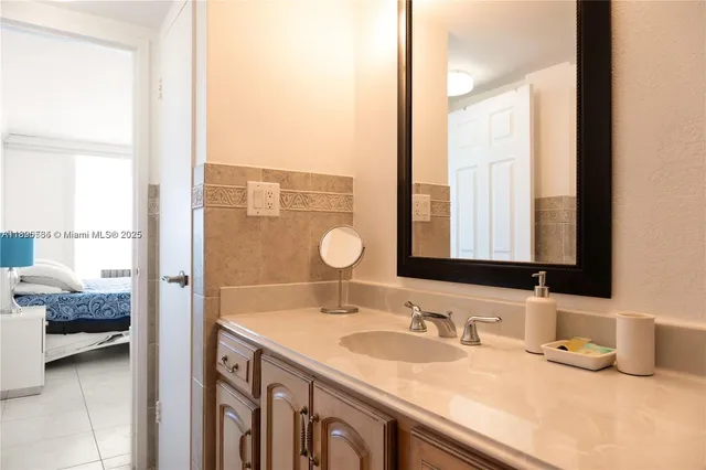a en suite bathroom with a granite countertop double vanity and a mirror