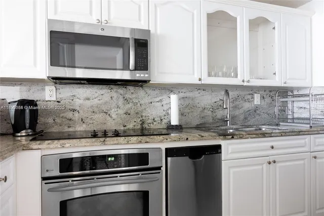 a kitchen with stainless steel appliances granite countertop a sink stove and microwave