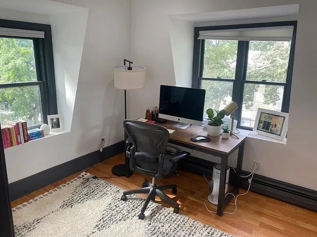 a view of a workspace with furniture and a window